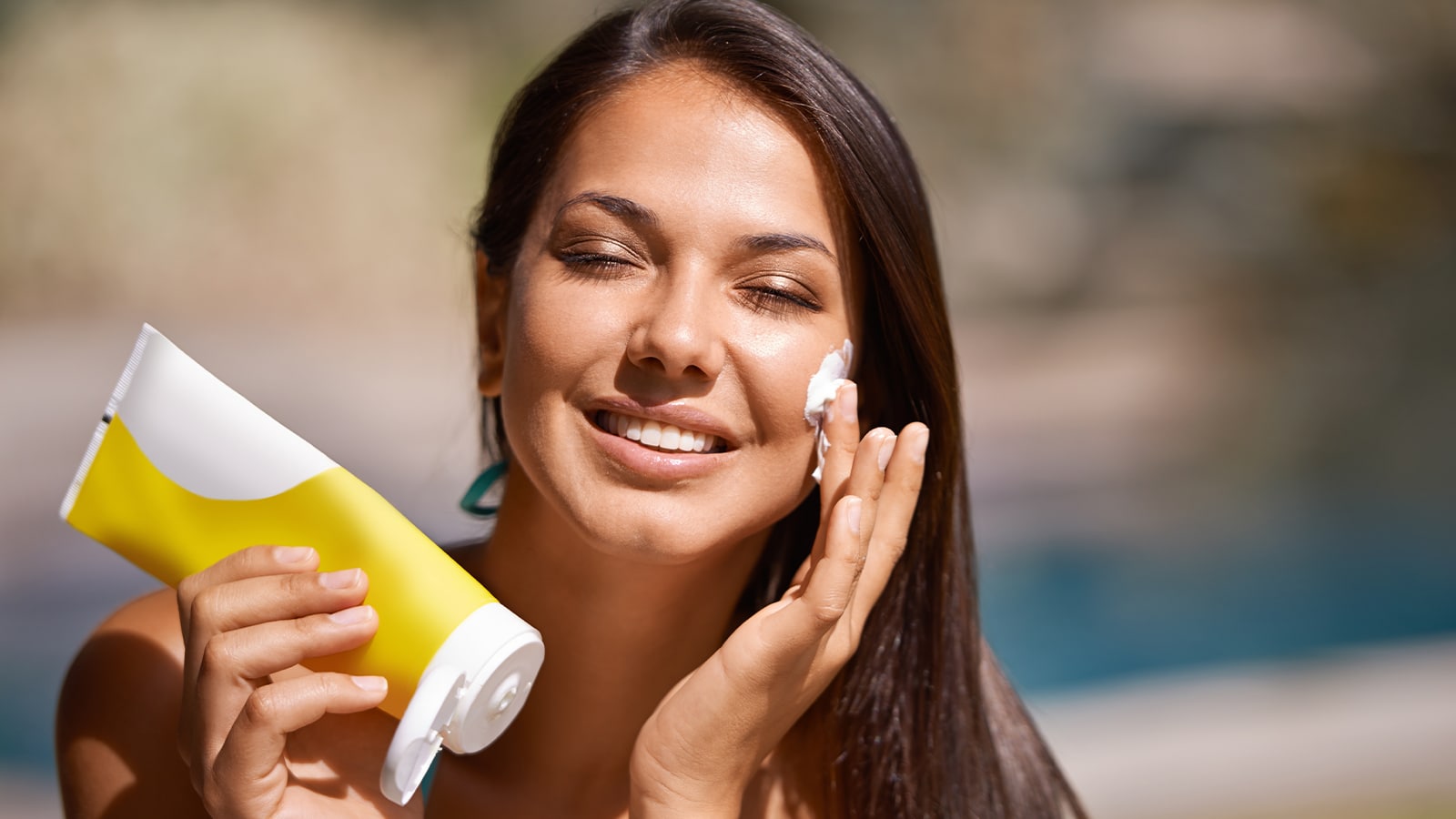 Woman with hair extensions applying sunscreen