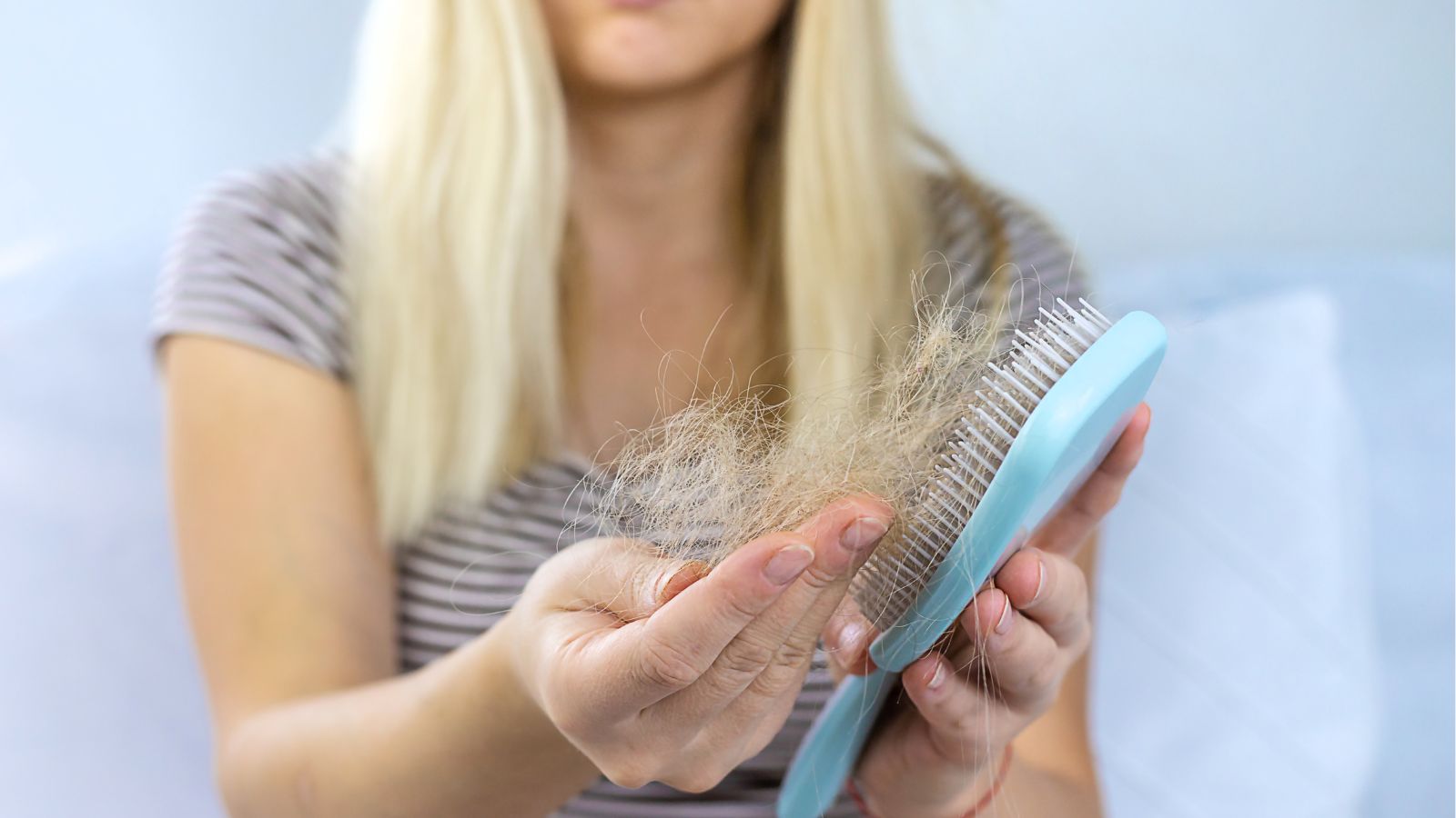 Woman losing hair in her hair brush