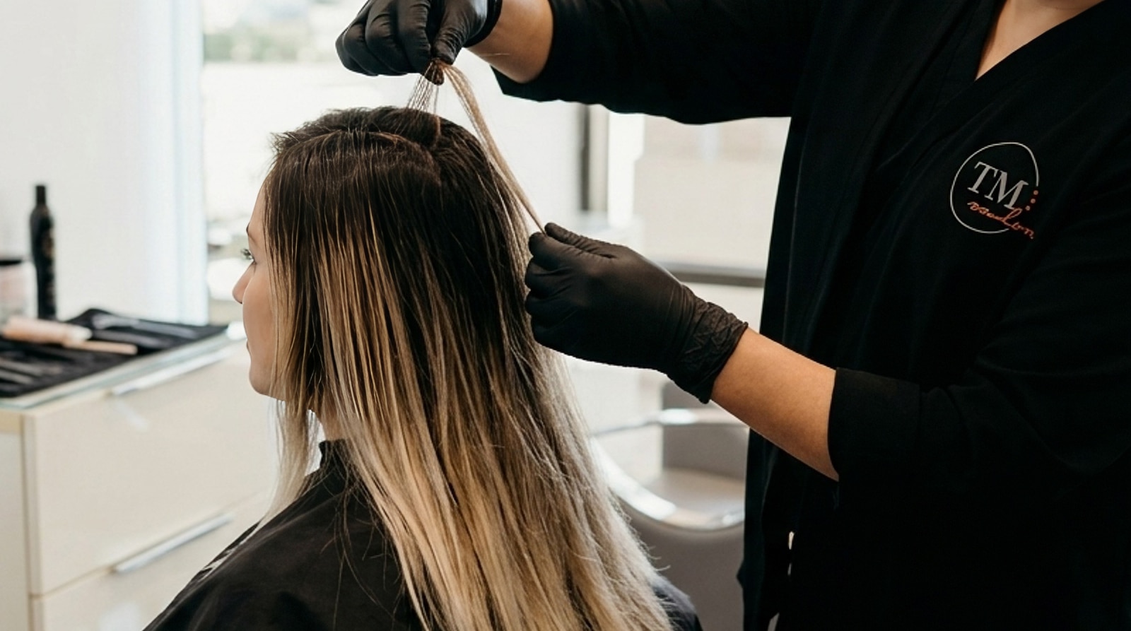 Stylist examines root regrowth and contrast to determine a client's personal highlights schedule